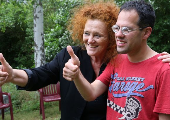 Daumen hoch zeigen eine Betreuerin und ein Lebensorte-Mitbewohner im roten Shirt, lachend schauen sie in dieselbe Richtung. Aufnahme bei einem Sommerfest