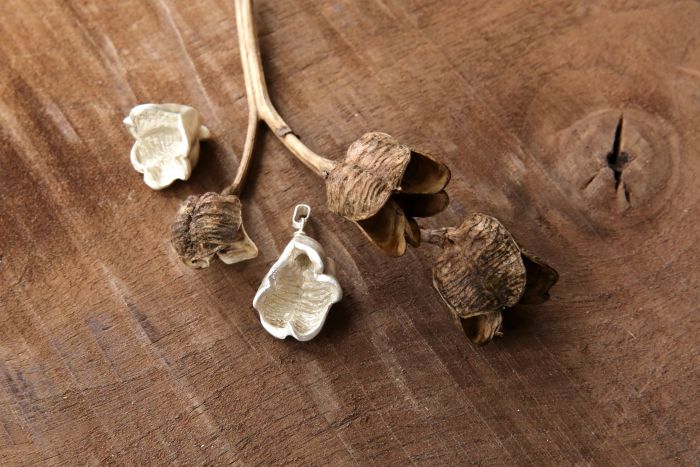Design-Schmuck aus Silber, die nach Objekten aus der Natur erstellt wurden auf Holz liegend