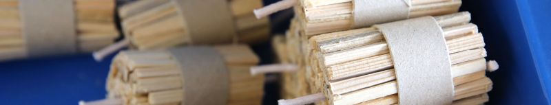 Anzünder aus Holz gebündelt und aufeinander gestapelt auf königsblauem Hintergrund