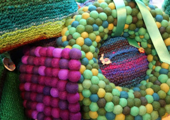 Filzprodukte aus unserer Werkstatt: violettfarbene und grüne Filzkugeln